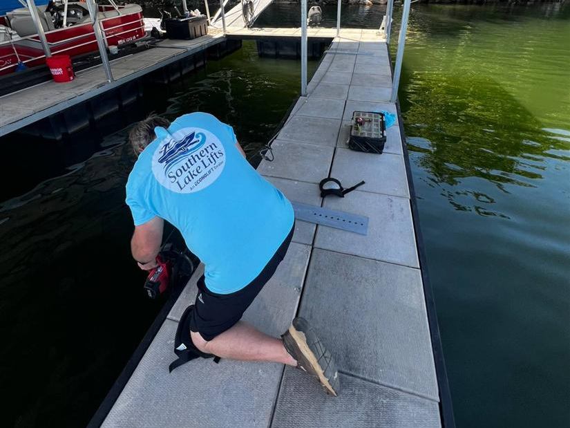 Southern Lakes Boat Lifts installer mounting lift hardware on a floating dock
