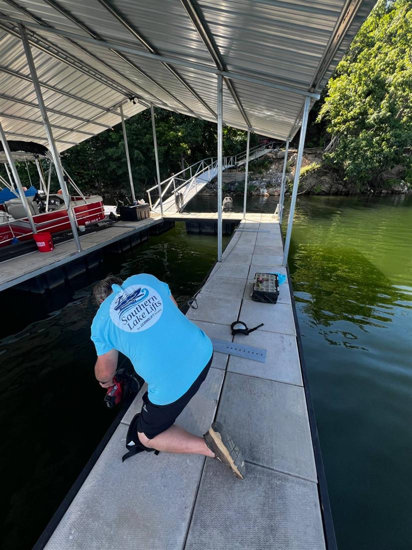 Installer drilling mounting points on a floating dock