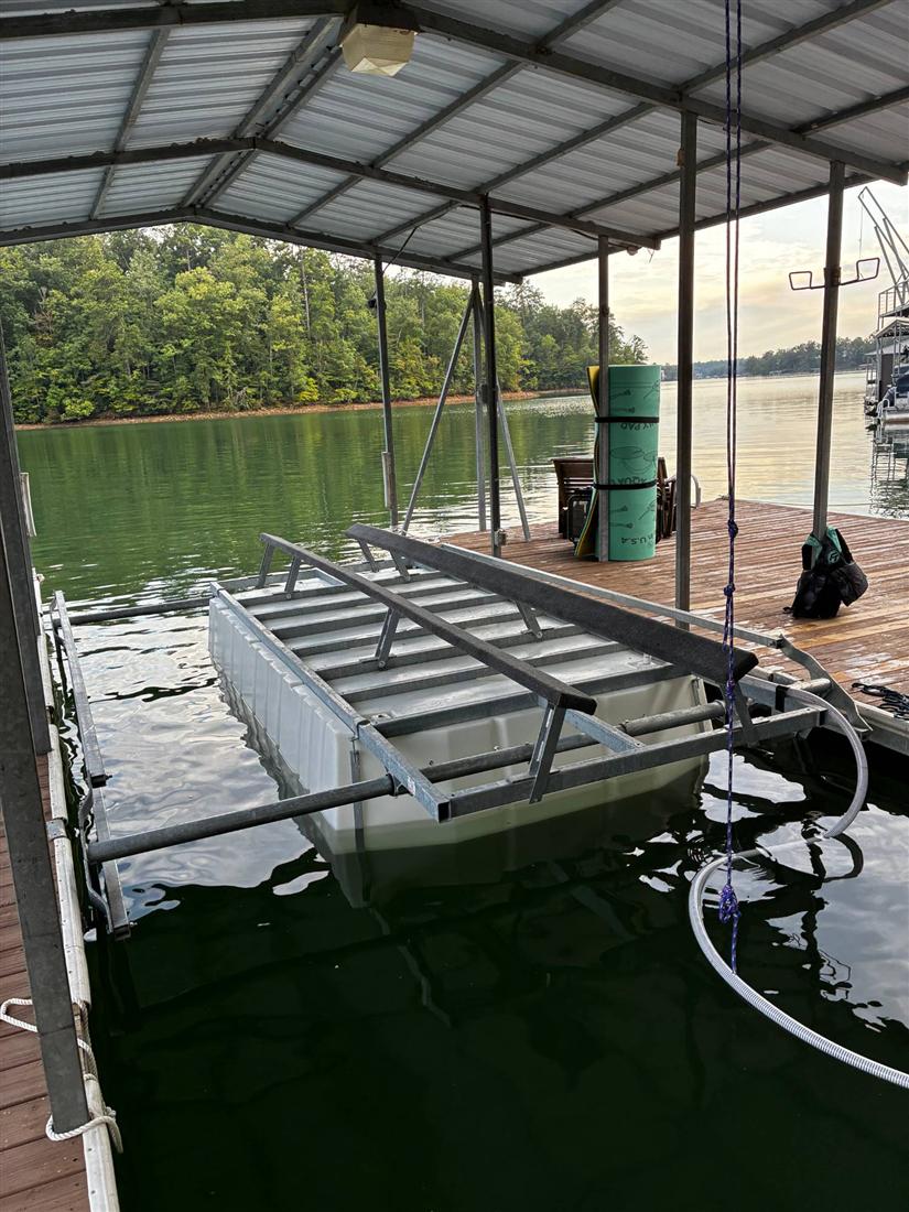 Air boat lift raised in a covered slip with tanks and bunks visible